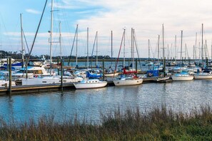 A marina with multiple sailboats docked at wooden piers.