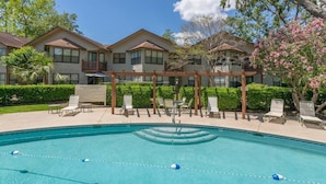 A pool area with lounge chairs and a pergola. - Enjoy being steps from the Pier Village at #508! (Saint Simons Island)