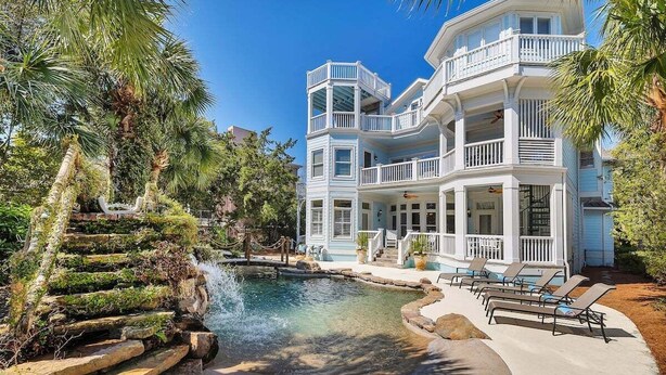 A multi-story building with balconies, a swimming pool, and a waterfall. - Large Luxury Home with Pool! (Saint Simons Island)