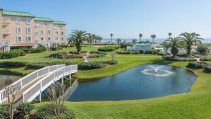 Un hotel con piscina, un puente y vista al océano.