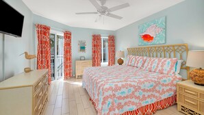 A bedroom with a bed, a dresser, a nightstand, a ceiling fan, and a television. - Beachfront Condominium Perfect for Small Families! Pool, Fitness Center, Tennis! (Saint Simons Island)