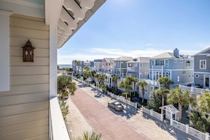 A row of coastal houses with a clear view of the street and parked cars.