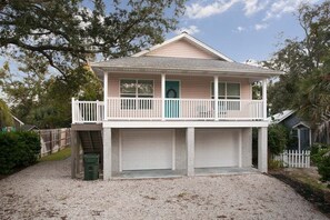 A two-story house with a balcony, a garage, and a front door.