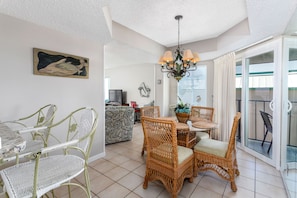 Relax in this spacious living area with a dining set and large sliding glass door leading to an outdoor balcony.