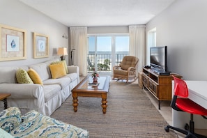 Relax in a spacious room with a comfortable seating area, featuring a sofa, side table, and wooden coffee table.