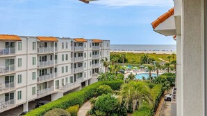 A multi-story hotel with balconies, a swimming pool, and a view of the beach. - Golden Isles Spacious Beachfront Condo (Saint Simons Island)