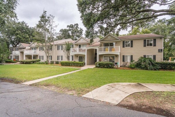 A row of two-story townhouses with balconies, a front lawn, and a driveway. - Ocean Walk Condo L14 (Saint Simons Island)