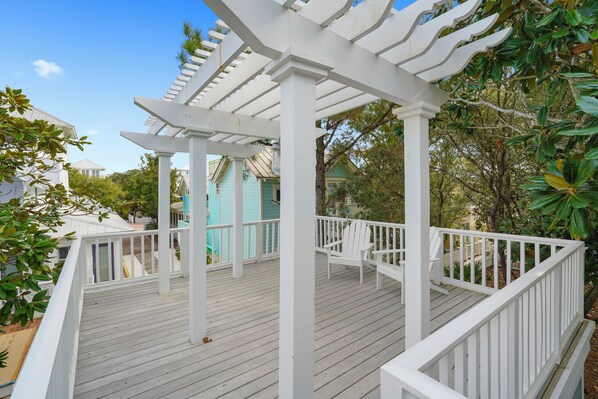 A white wooden deck with a pergola, white railings, and a chair. - Three Houses Down From Beach In Seaside, FL, Double Lot + 2 Adult Bikes! (Santa Rosa Beach)
