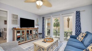A living room with a sofa, a wooden coffee table, a television, and a cabinet. - Oceanfront and Great Amenities! (Saint Simons Island)