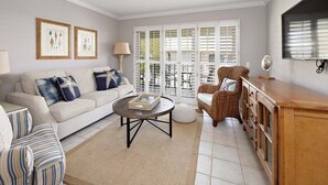 A living room with a sofa, armchairs, a coffee table, and a wooden cabinet. - Oceanfront Condominium on St Simons! (Saint Simons Island)