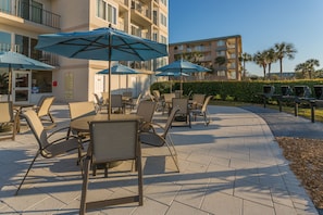 Relax on the patio with comfortable seating and shade from umbrellas.