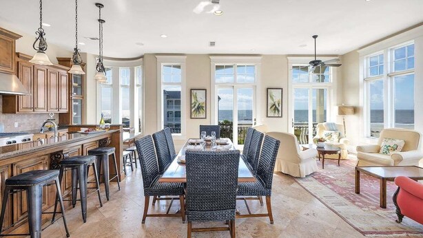 A spacious kitchen with a dining area, large windows, and a view of the ocean. - Luxurious Complex. Steps from the Beach! (Saint Simons Island)