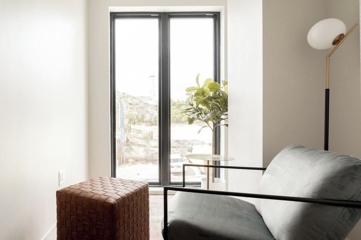 Ein modernes Wohnzimmer mit einer Couch, einem kleinen Tisch und einer Stehlampe.