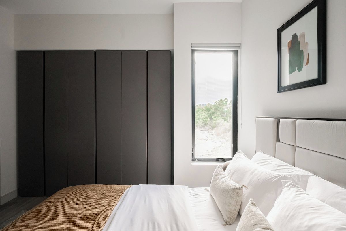 Ein Schlafzimmer mit einem Bett, einem Fenster und einem Kleiderschrank.