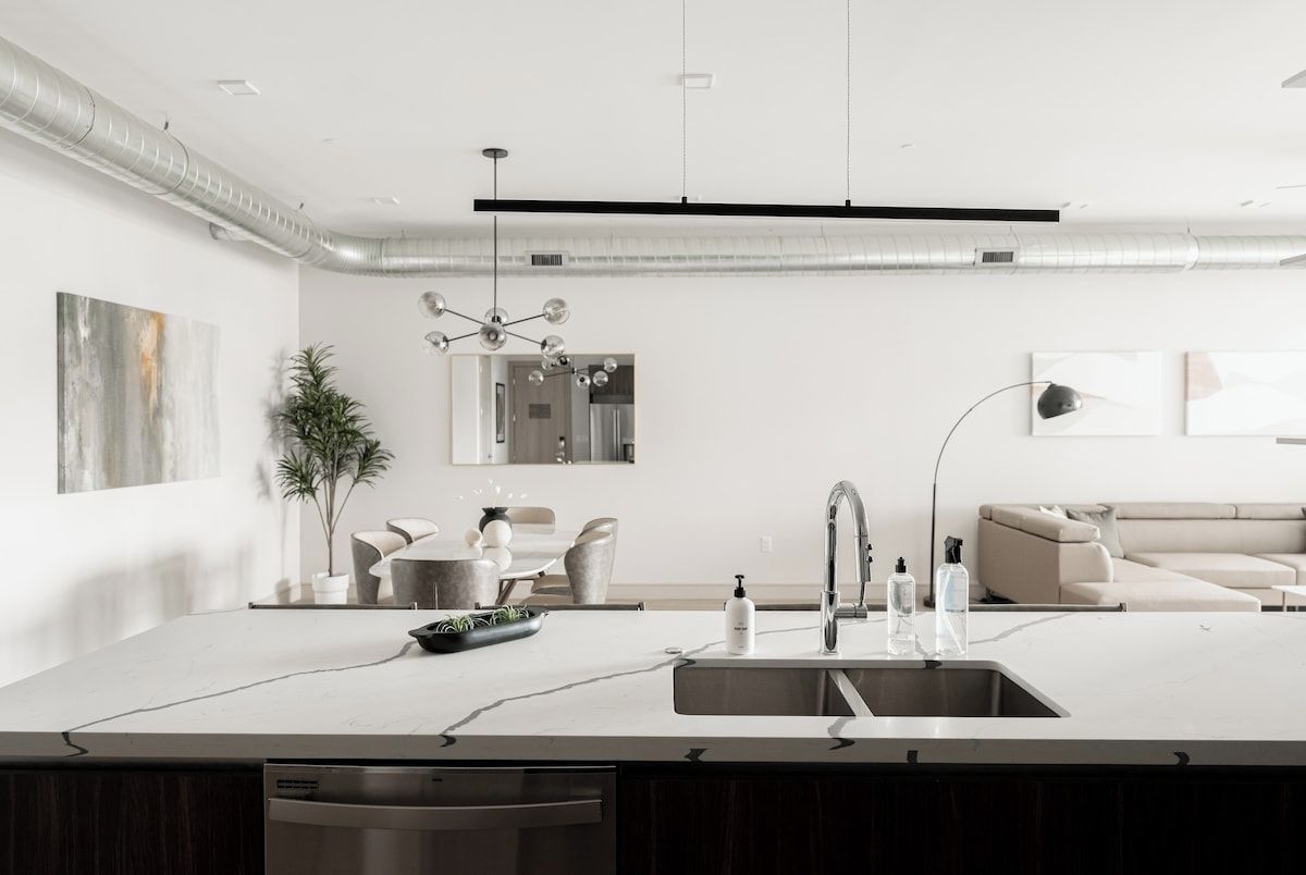 Eine moderne Küche mit einer zentralen Kochinsel, Edelstahlgeräten und einem minimalistischen Design.