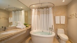 Un bagno moderno con una vasca da bagno indipendente, un water e un mobile lavabo con lavandino.