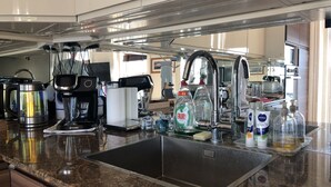 A modern kitchen with a stainless steel sink, Bosch coffee maker, and various kitchen appliances. - Apartment - Sleeps 4 - Balcony - Sea View (Eastbourne)