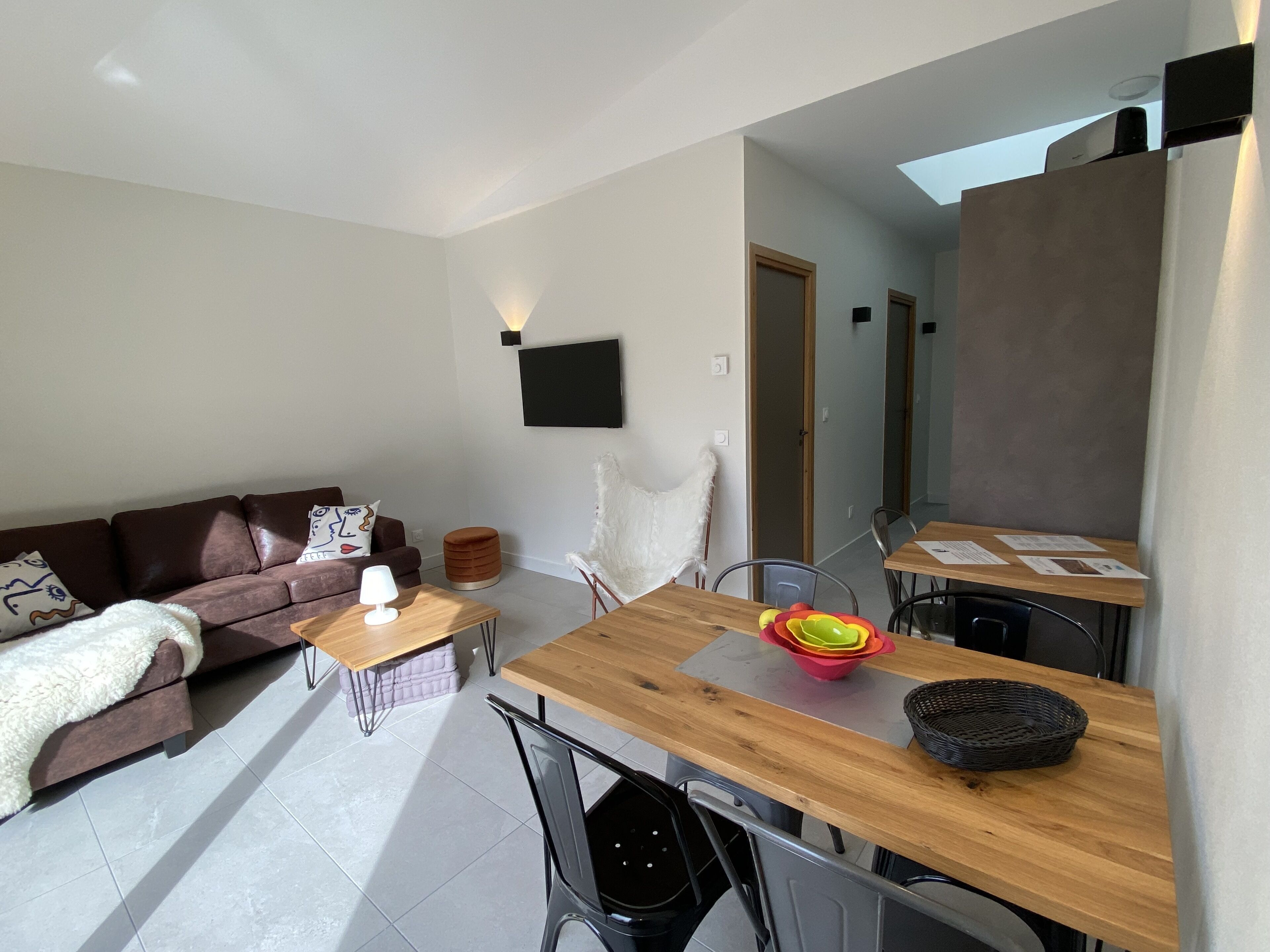 Ein modernes Wohnzimmer mit einer Couch, einem Couchtisch und einem Esstisch mit Stühlen.