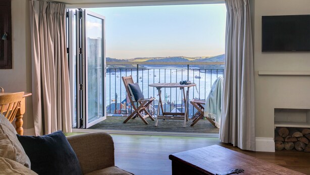 A balcony with a view of the sea, a table with chairs, and a sofa. - Magdala - 5 BR property Sleeps 10 w/stunning views (Salcombe)