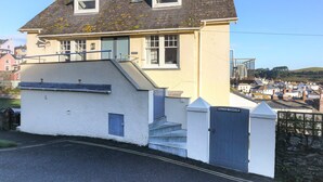 A two-story building with a white facade, a blue roof, and a small balcony. - Magdala - 5 BR property Sleeps 10 w/stunning views (Salcombe)