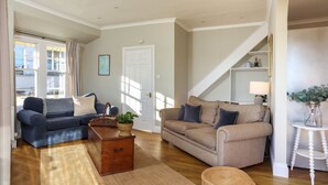 A living room with two sofas, a wooden chest, and a small table with a plant. - Magdala - 5 BR property Sleeps 10 w/stunning views (Salcombe)