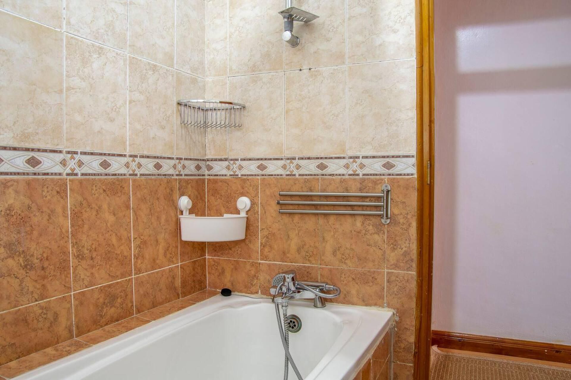Ein Badezimmer mit Badewanne, Dusche und Handtuchhalter.