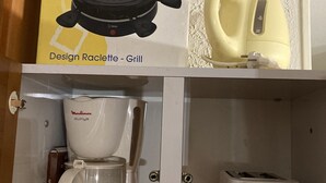 Une cuisine équipée d’une machine à café, d’un grille-pain et d’un appareil à raclette.