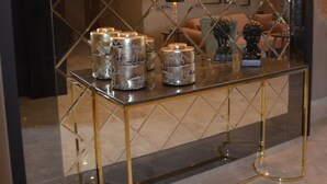 A modern interior with a glass coffee table, gold legs, and decorative items. - Hotel Vela Verde (Yalova)