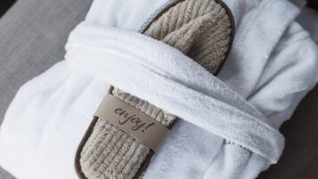A pair of slippers wrapped in a white towel with a tag that says 'enjoy!'