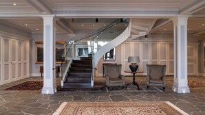A spacious foyer with a grand staircase, stone flooring, and a large rug. - Marstrands Kurhotell  (Marstrand)