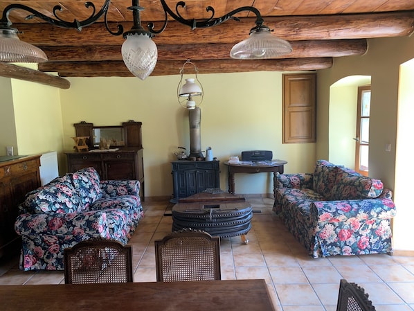 A cozy living room with floral-patterned sofas, a wooden coffee table, and a vintage radio.