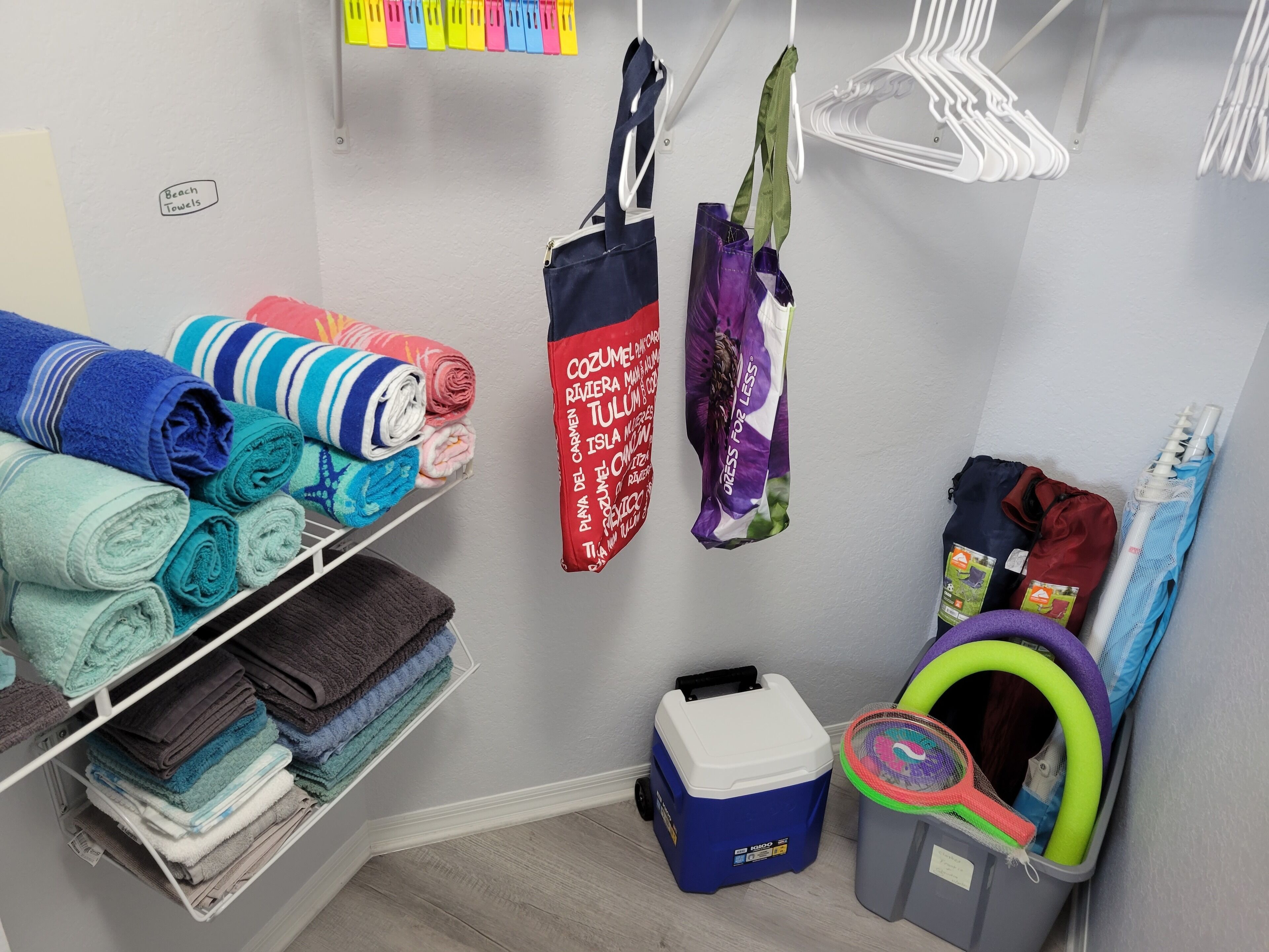 A neatly organized storage area with towels, bags, and a cooler.