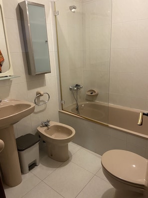 Bathtub, hair dryer, towels, toilet paper