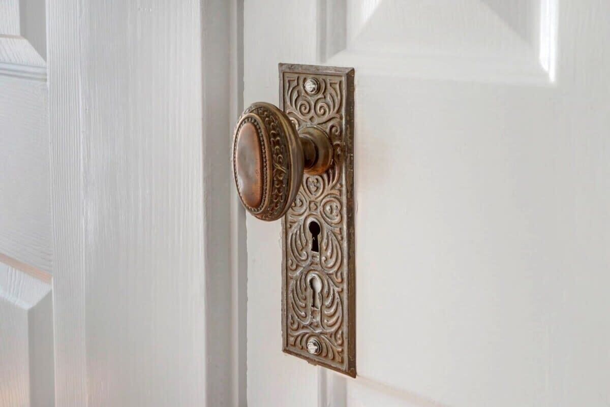 Une porte dotée d’une serrure et d’une poignée décoratives, de style ancien.