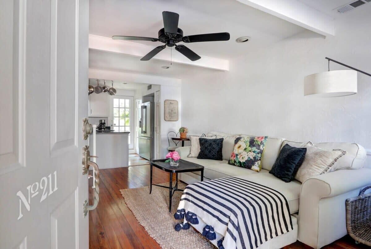 A modern living room with a sofa, a coffee table, and a ceiling fan.