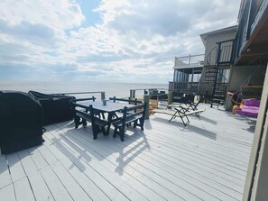 A deck with a table and chairs, overlooking the sea.