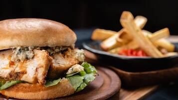 A sandwich with a bun, lettuce, and a creamy sauce, accompanied by a side of fries.