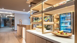 A modern kitchen area with wooden cabinets, a countertop, and a fruit bowl. - Fairfield by Marriott Medellin Sabaneta (Sabaneta)