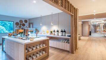 A modern kitchen area with a central island, wooden cabinets, and a large window.