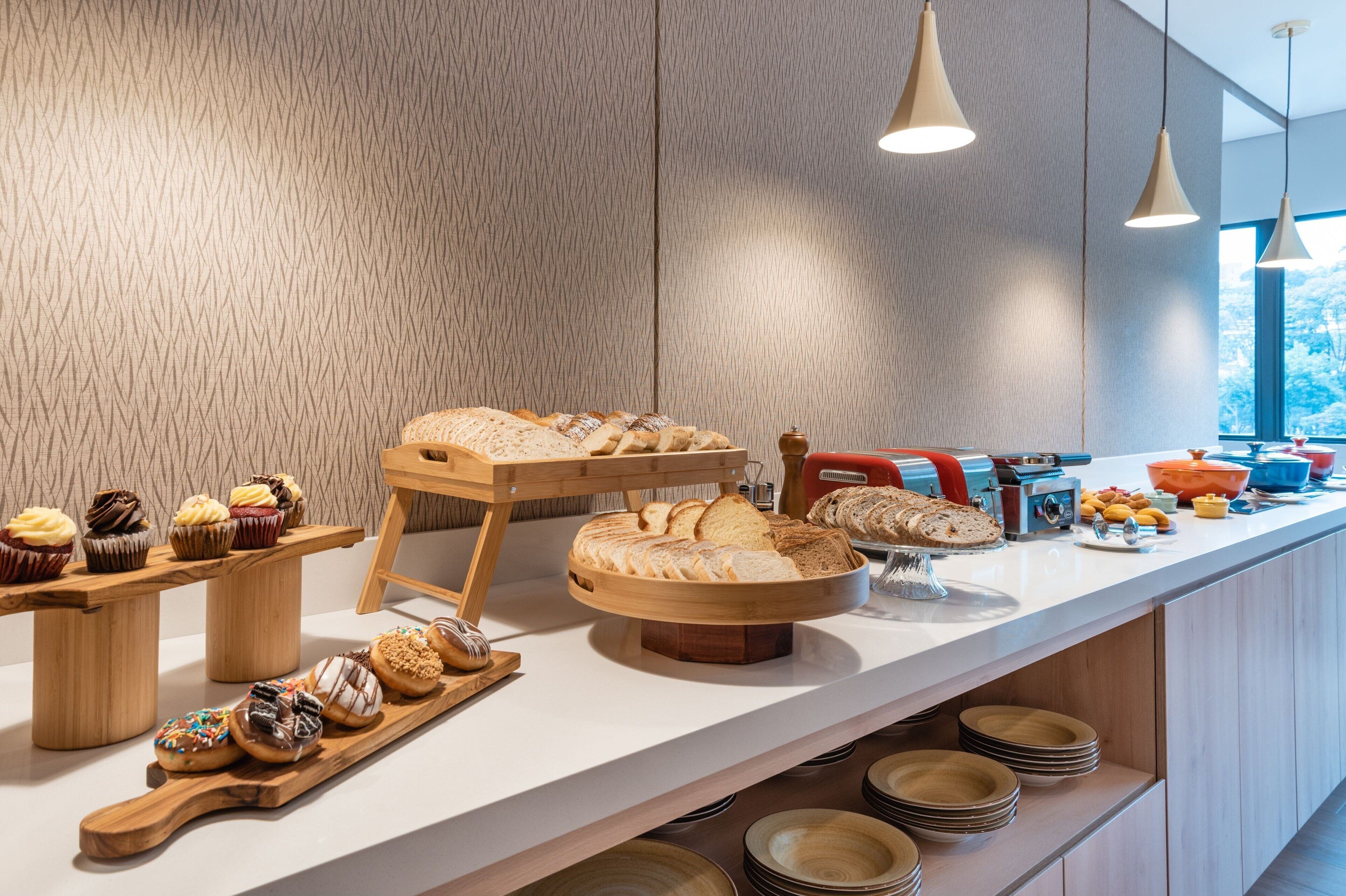 Een ontbijtbuffet met diverse gebakjes, brood en fruit.