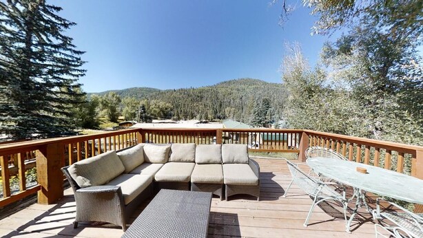 A deck with a sofa, chairs, and a table.