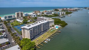 Un hôtel de grande hauteur, avec de nombreux étages, un port de plaisance avec des bateaux et une vue sur l’océan.