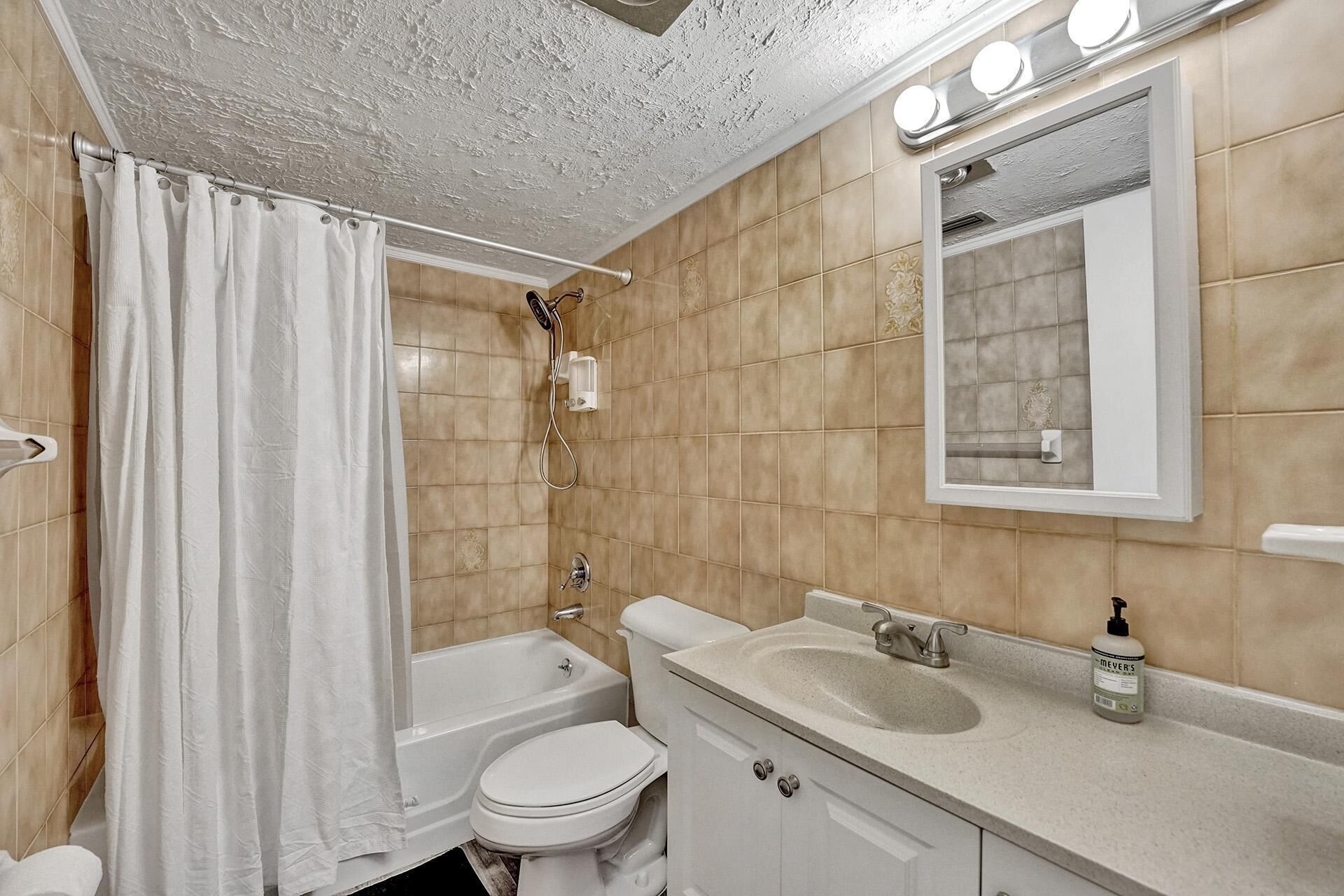 Une salle de bain avec une baignoire, des toilettes, un lavabo et un miroir.