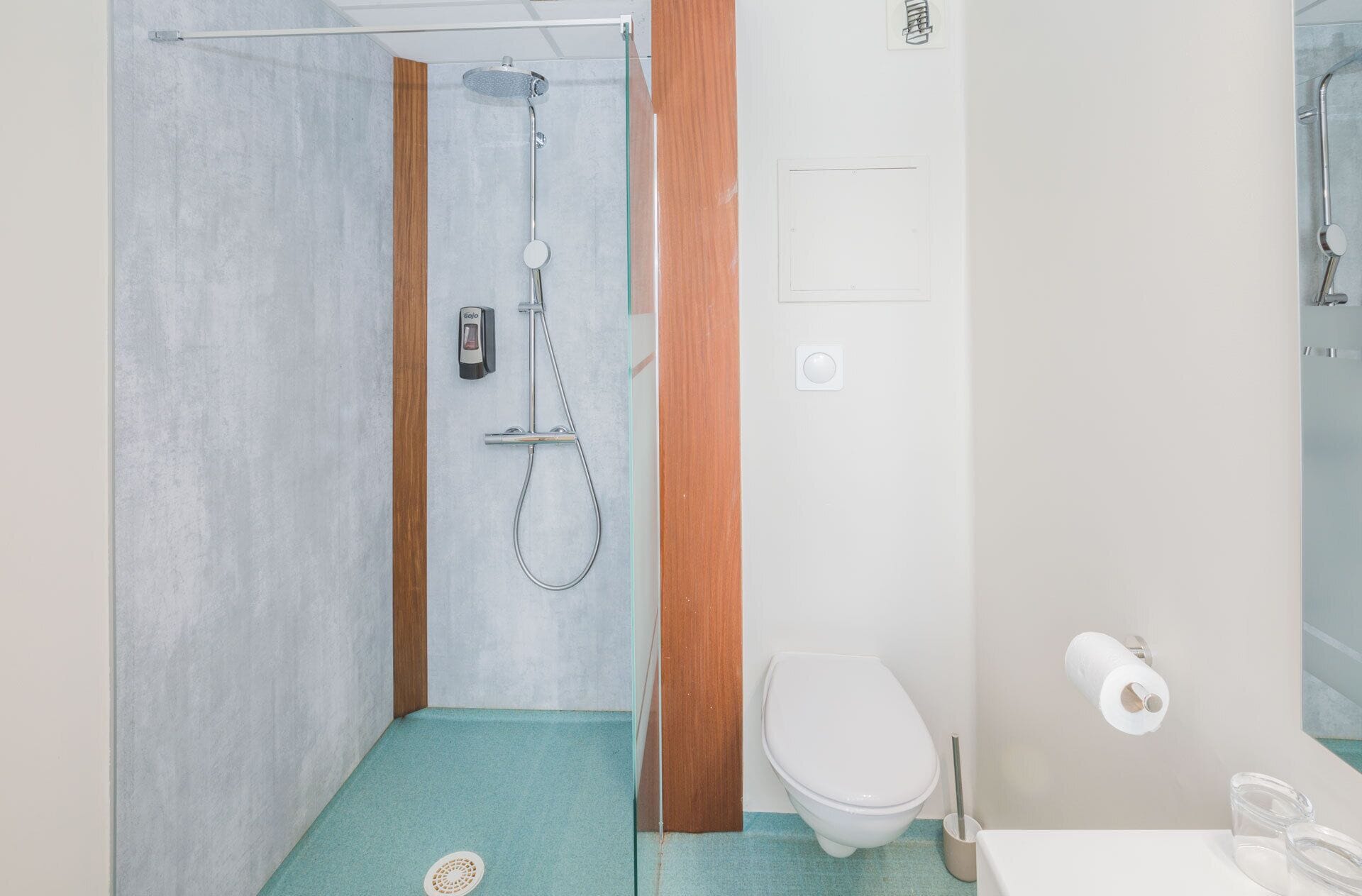 A bathroom with a shower, toilet, and sink.