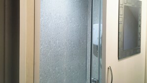 A bathroom with a glass shower enclosure and a wall-mounted control panel. - Short Term Shared R&R In Chorlton (Manchester)