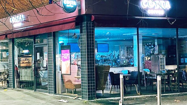 A Costa Coffee shop with a modern exterior and large glass windows. - Short Term Shared R&R In Chorlton (Manchester)