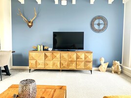 Apartamento Deluxe | Zona de estar | Smart TV de 55 pulgadas con canales por satélite, una televisión