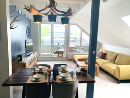 Apartamento Deluxe | Zona de estar | Smart TV de 55 pulgadas con canales por satélite, una televisión