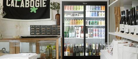 A cold beer refrigerator stocked with various beverages, a display of folded towels, and a sign reading "CALABOGIE".