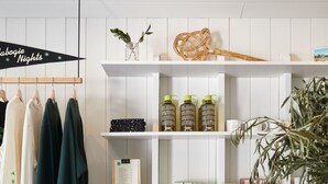 Una habitación ordenada con estantes blancos que exhiben diferentes objetos como ropa, velas y artículos de aseo.